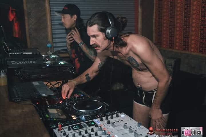MR. SATAN DJing shirtless at a set.