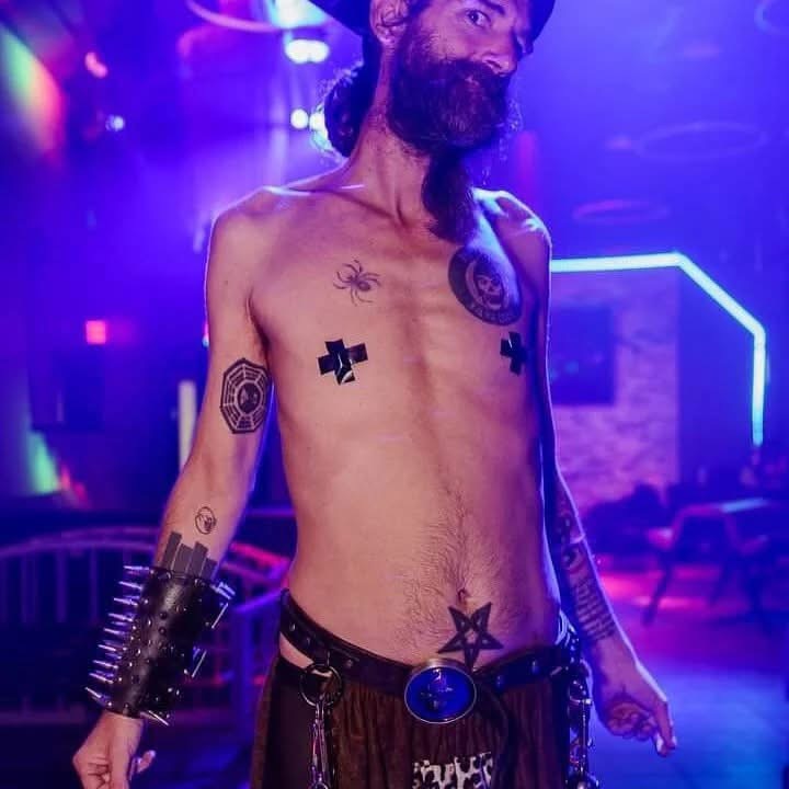 MR. SATAN under club lights with tape crosses.